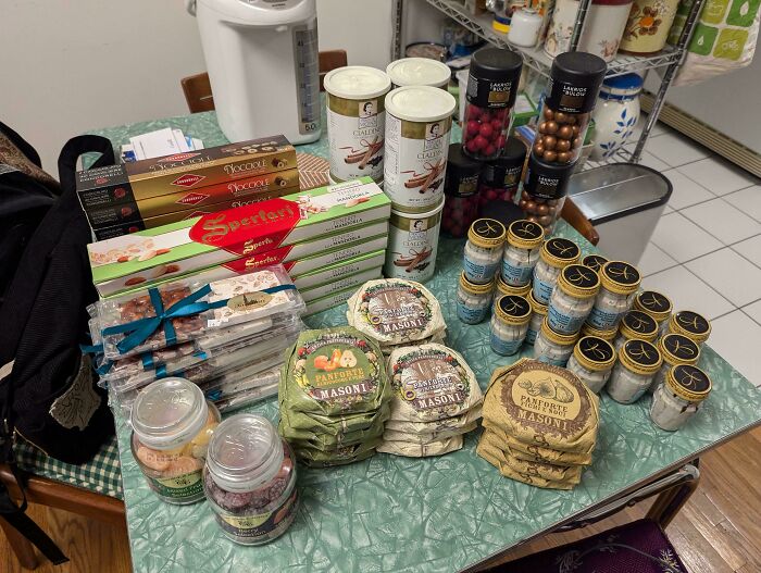 Assorted gourmet snacks and packaged goods on a green table, found while dumpster diving.