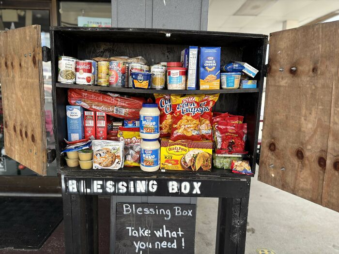 Blessing Box filled with various food items, open for community sharing, highlighting dumpster diving finds.