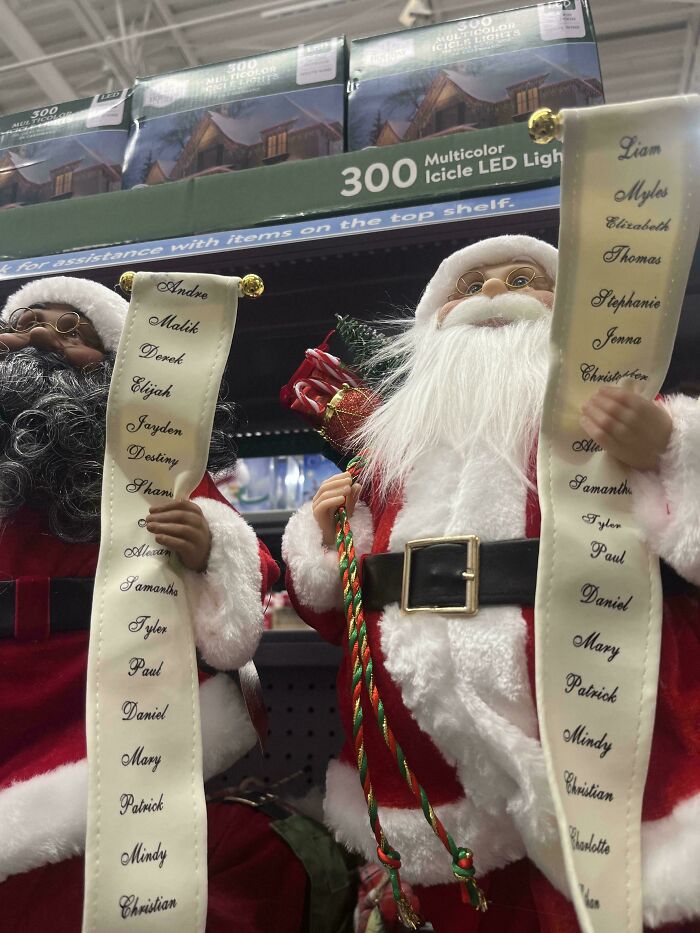 Two Santa Claus figures hold list of names under multicolor icicle LED lights, offering mildly interesting holiday decor.