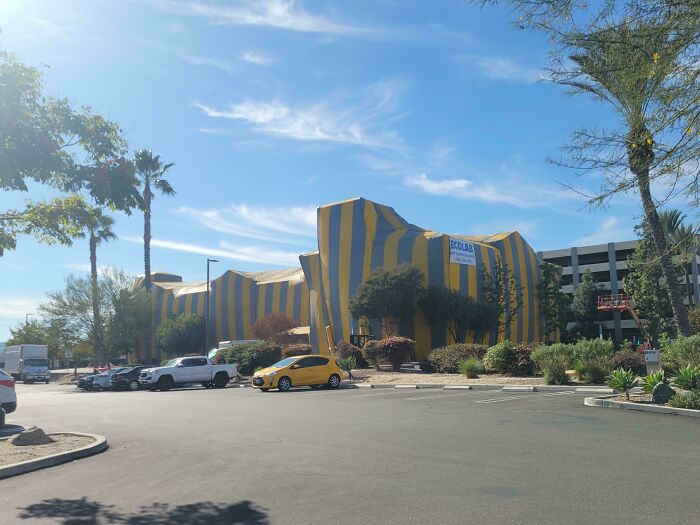 Yellow and blue striped building with unique architecture under a clear sky, mildly interesting scene.