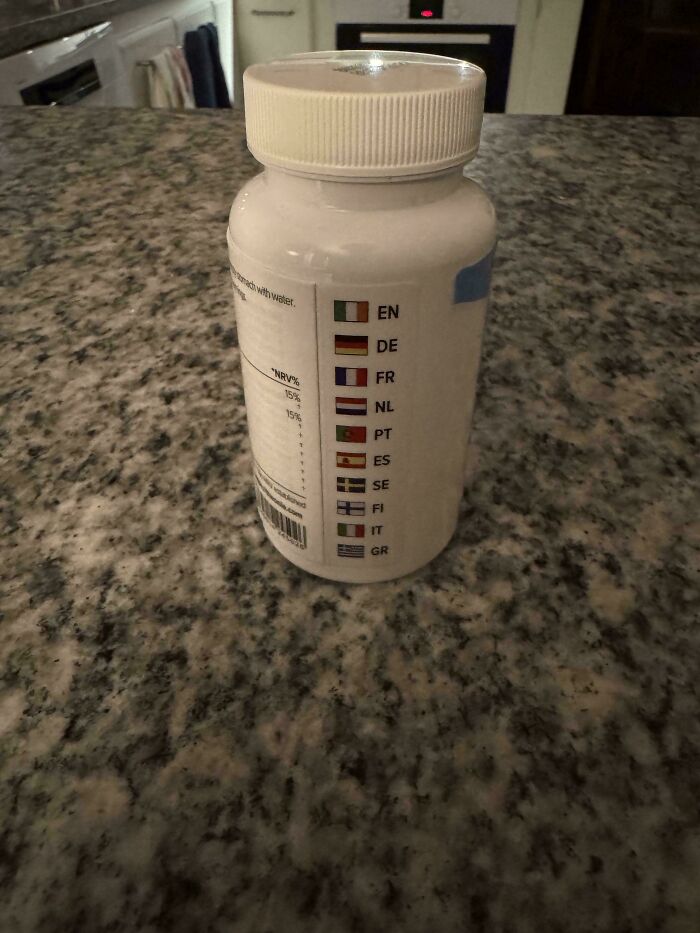 A bottle on a countertop displays flags indicating different languages, adding mildly interesting detail to its label design.