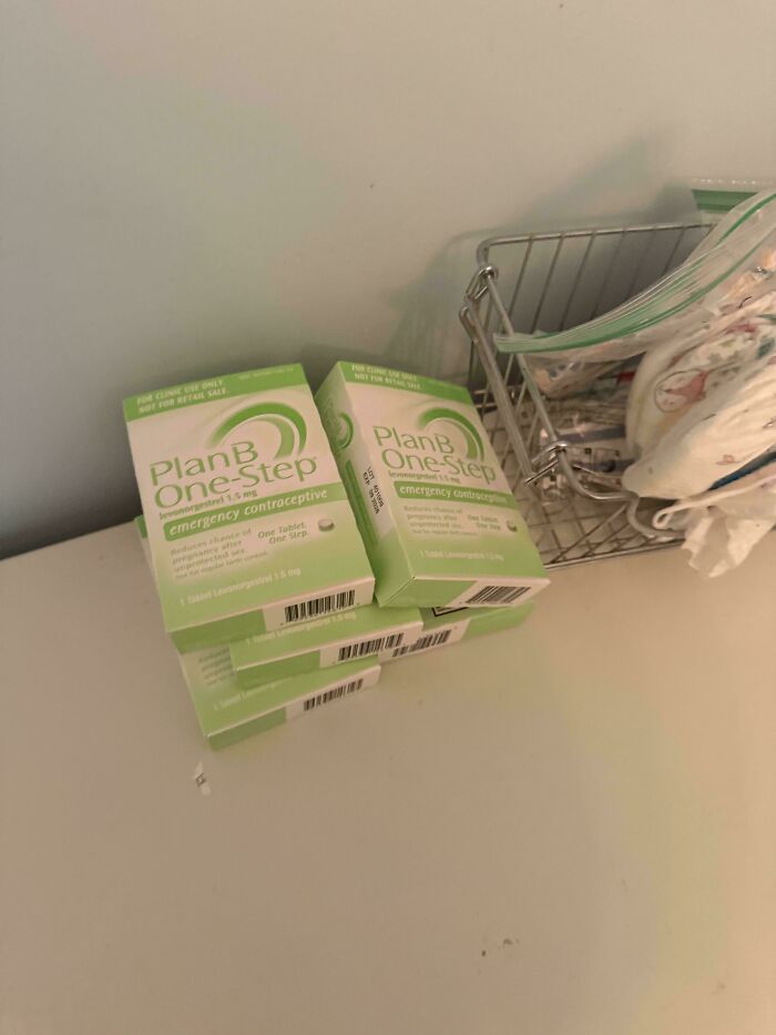 Stack of Plan B One-Step boxes on a shelf next to a wire basket. Mildly interesting.