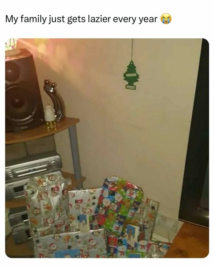 Stack of lazily wrapped Christmas presents next to a speaker and stereo, showing a family's barely holding it together moment.