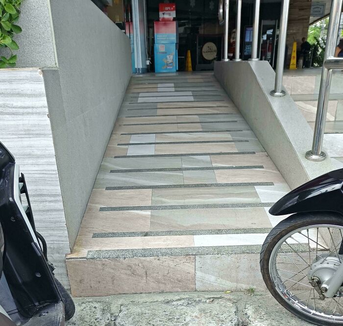 Ramp with a large step defeating its purpose, showcasing a hilarious perfectly preventable fail in construction design.