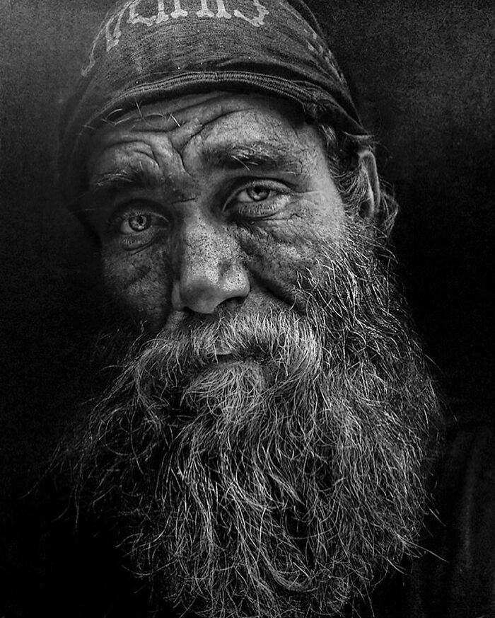 Portrait by Lee Jeffries of a bearded man with deep, expressive eyes, showcasing street life.