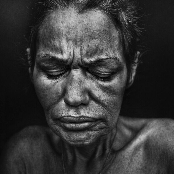 A soulful portrait by Lee Jeffries featuring a woman with eyes closed and a pensive expression.