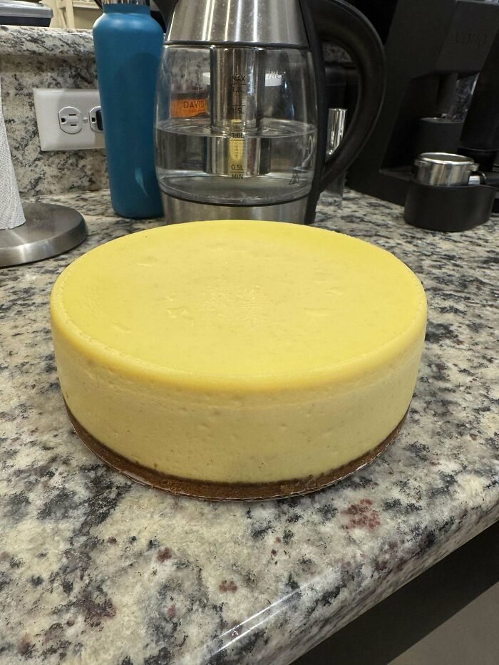 A perfectly baked cheesecake on a granite countertop, showcasing culinary artistry.