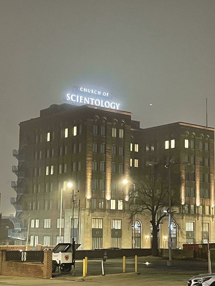 Church of Scientology building lit at night, exuding an eerie vibe fitting a supervillain headquarters with an evil aura.