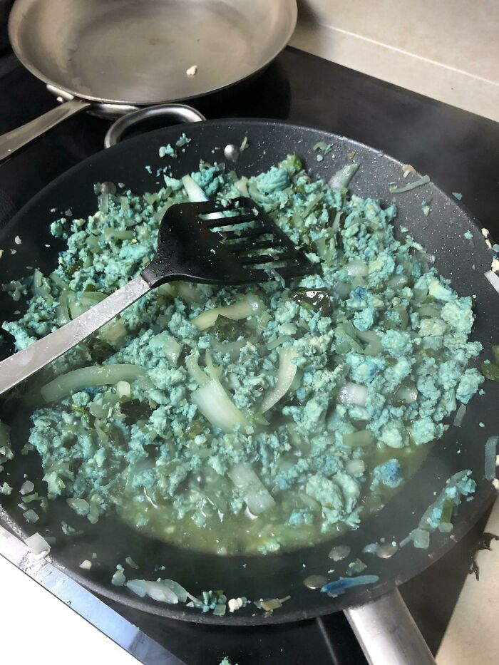 Unhinged food: Blue-green ground meat cooking in a frying pan with onions.