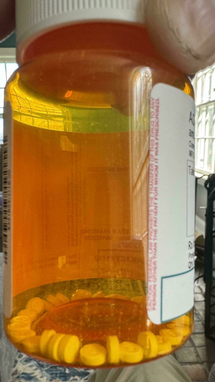 Prescription bottle mostly empty, highlighting wasteful unnecessary packaging for pills.