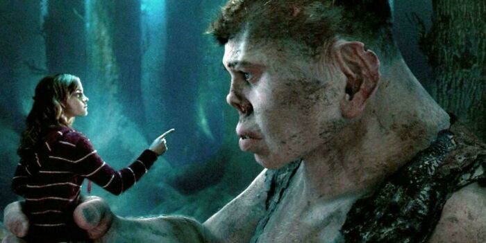 Young woman pointing at a giant creature in a dark forest scene highlighting questionable movie details for cinephiles.