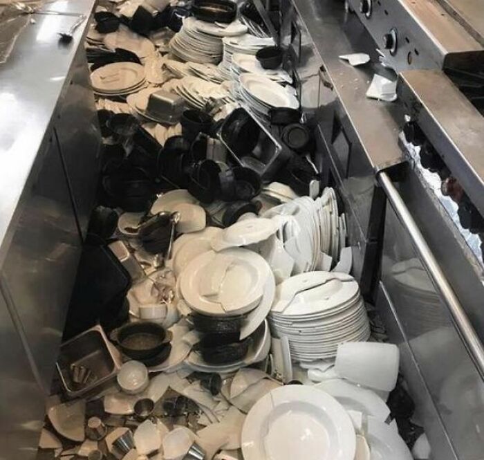 Kitchen floor covered in a chaotic pile of broken dishes and cookware, illustrating really messed up moments in a kitchen.
