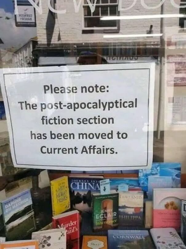Weird sign about post-apocalyptic fiction moved to Current Affairs section, spotted in a bookstore window display.