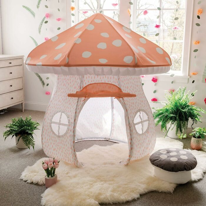 Mushroom-shaped play tent for kids in a bright room with plants and soft rugs, appealing to fans of peak coolness.