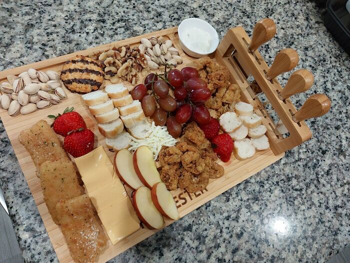 Charcuterie board with assorted cheeses, fruits, nuts, and crackers, a perfect Christmas gift idea for moms.