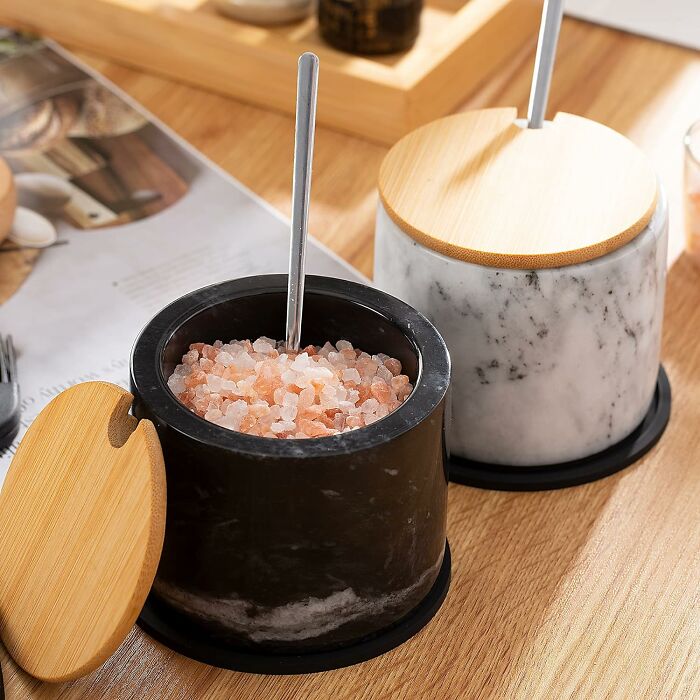 Marble salt cellars with lids and spoons, showcasing unique kitchen items.