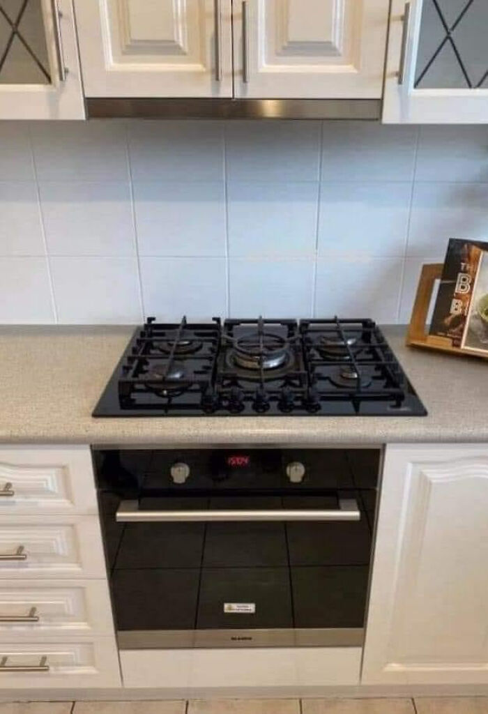 Stovetop installed beneath cabinet, exemplifying funny, cheap construction fails.