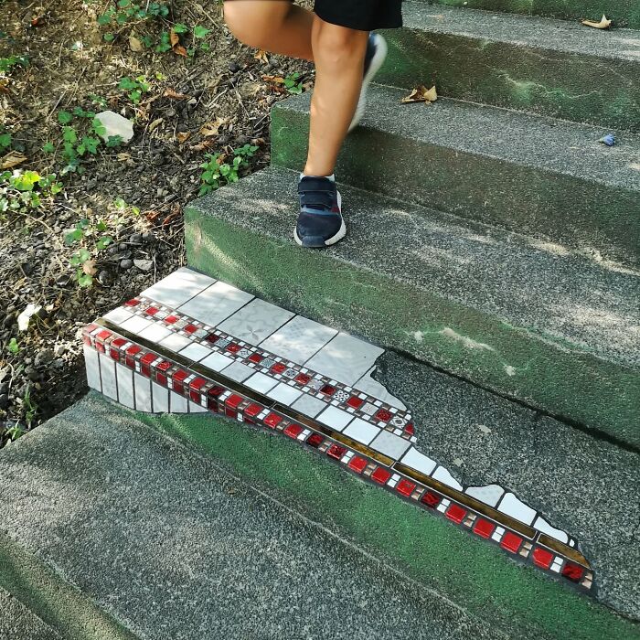 Person walking near vibrant mosaic art mending c*****d steps.
