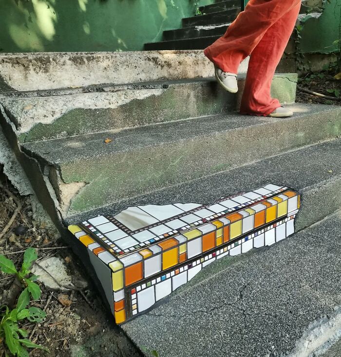 Vibrant mosaic art mends c*****d sidewalk step.
