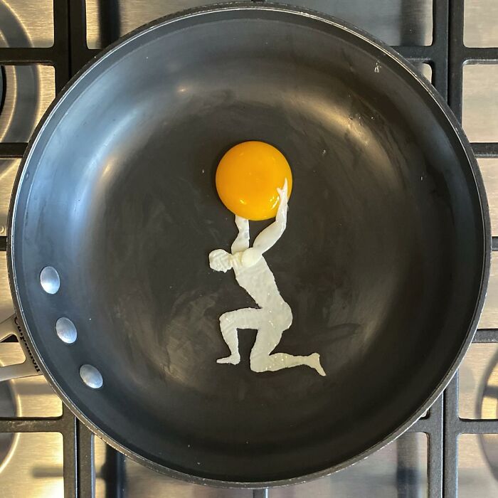 Creative way of frying an egg with yolk resembling a person holding a sphere in a frying pan.