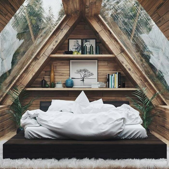 Cozy tiny home bedroom with triangular roof, wooden walls, and a bed under large windows.