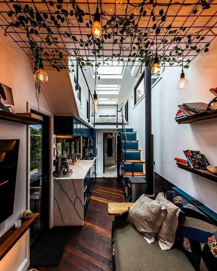 Interior of a dreamy tiny home with stylish lighting, plants, and modern decor.