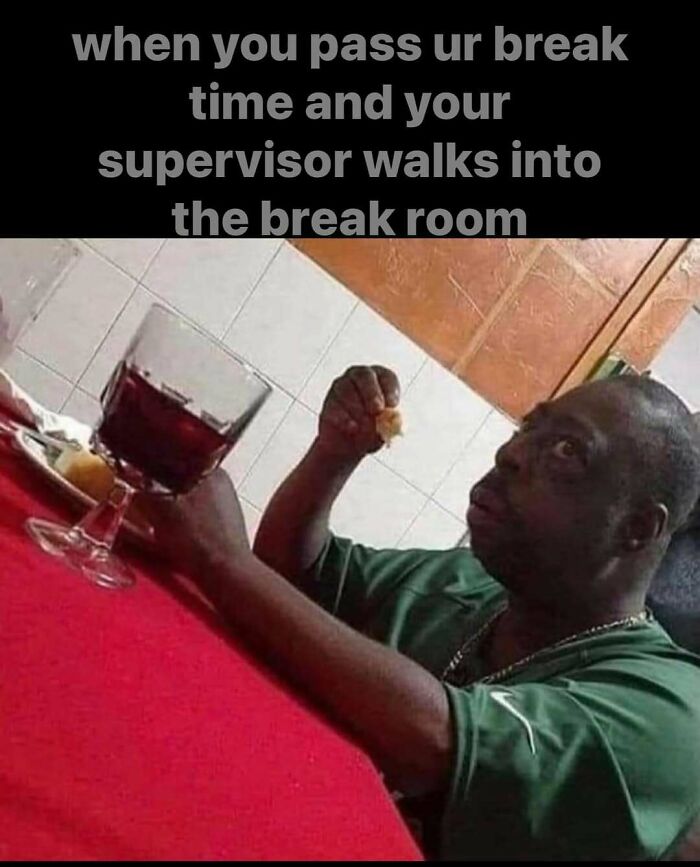 Man in break room looking startled, holding food, with a drink on table; humorous work meme about supervisors.