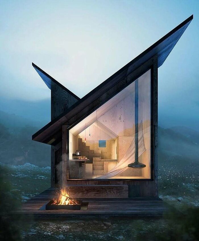 Contemporary tiny home with geometric design, large window, and cozy interior, set in a serene natural landscape.