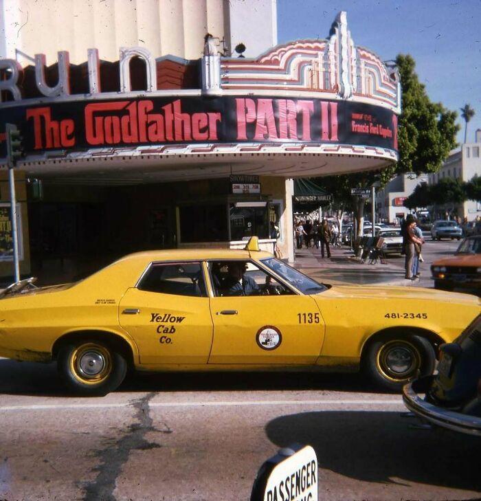 Yellow cab in front of 1970s West Coast theater showing "The Godfather Part II."