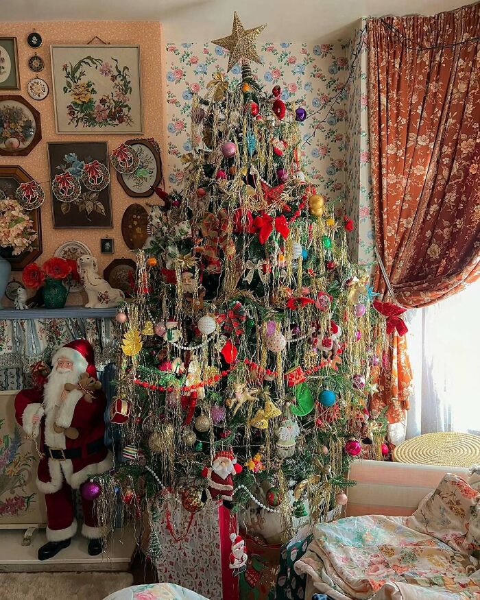 Decorated Christmas tree with colorful ornaments, tinsel, and a star topper, surrounded by vintage decor.