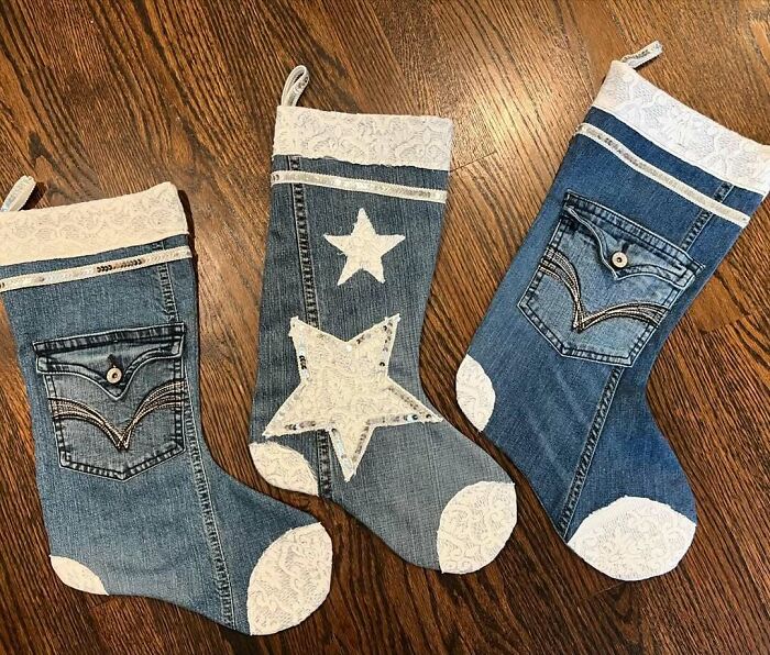 DIY Christmas stockings made from denim jeans with star and pocket designs on wooden floor.