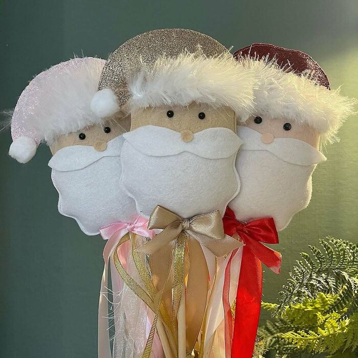 DIY Christmas decorations featuring three felt Santa faces with colorful ribbon beards.