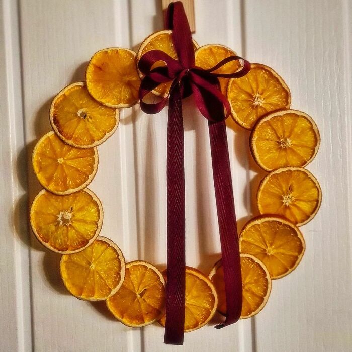 DIY Christmas wreath made from dried orange slices with a red ribbon bow.