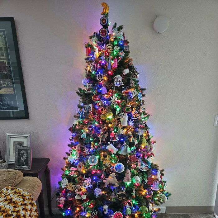 Vibrant Christmas tree decorated with colorful lights and ornaments in a cozy living room, showcasing festive holiday style.