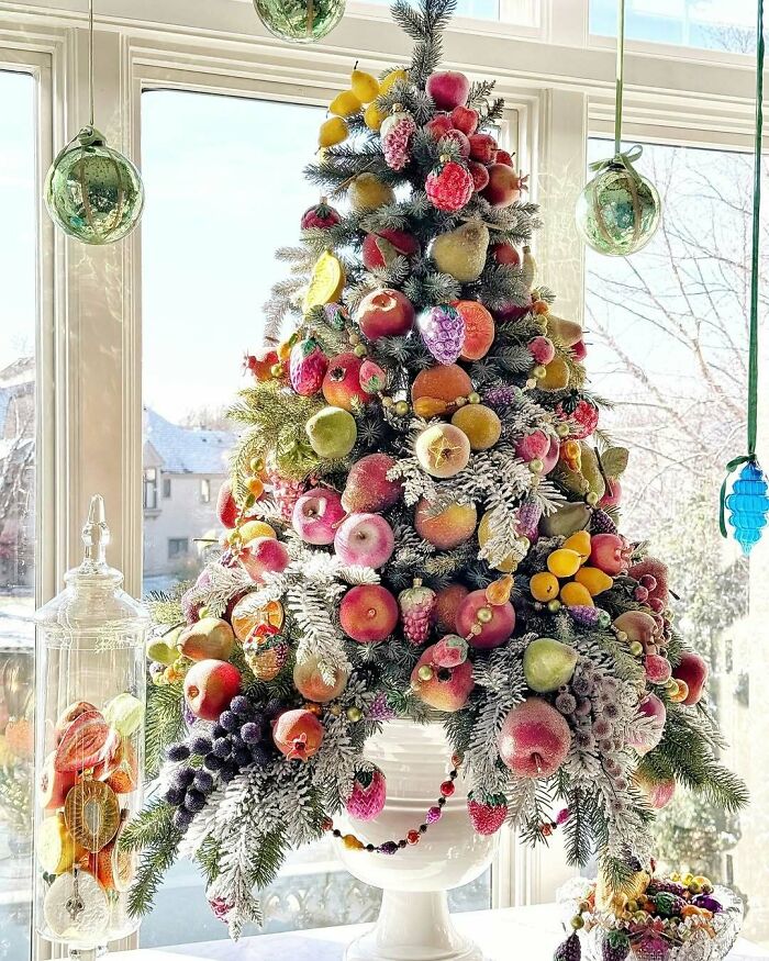 Fruit-decorated Christmas tree idea in a bright room, featuring apples, pears, and berries, adding a festive touch.