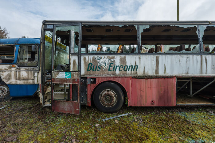Abandoned Irish bus at ghost bus graveyard, rusted and weathered with broken windows.