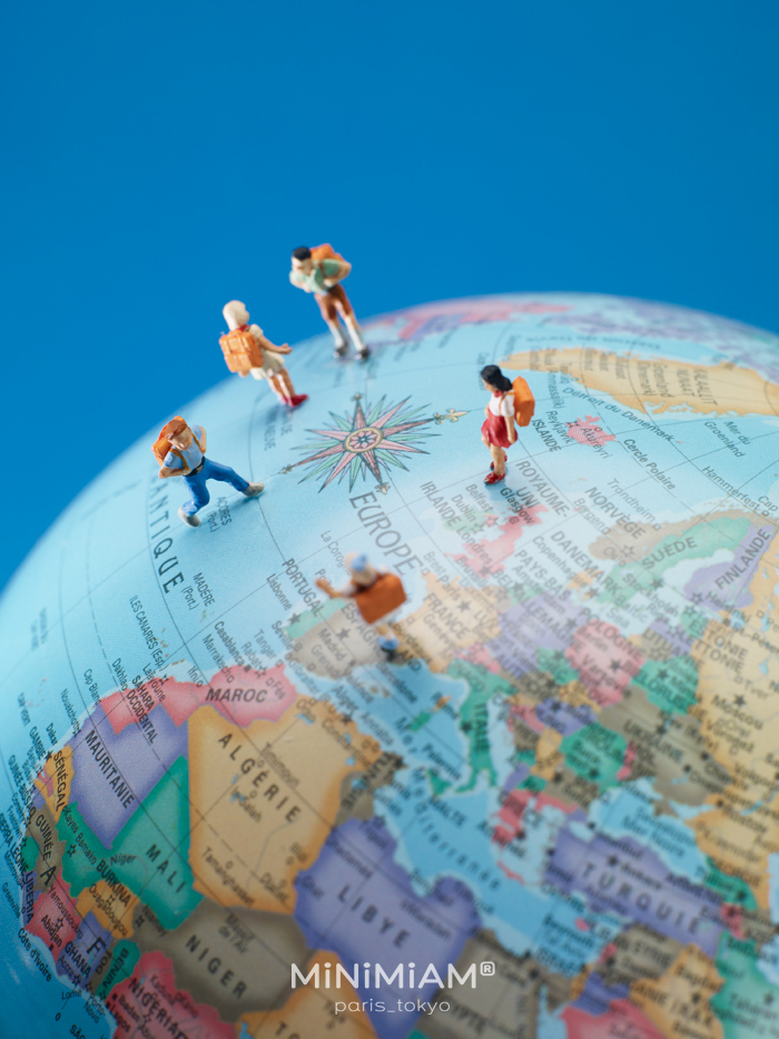 Miniature hikers walking on a globe, depicting Europe, by creative duo from MiniMiam.