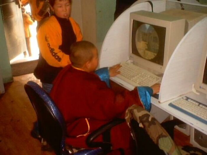 A young monk using an old computer, evoking an old-internet feel in a retro setting.