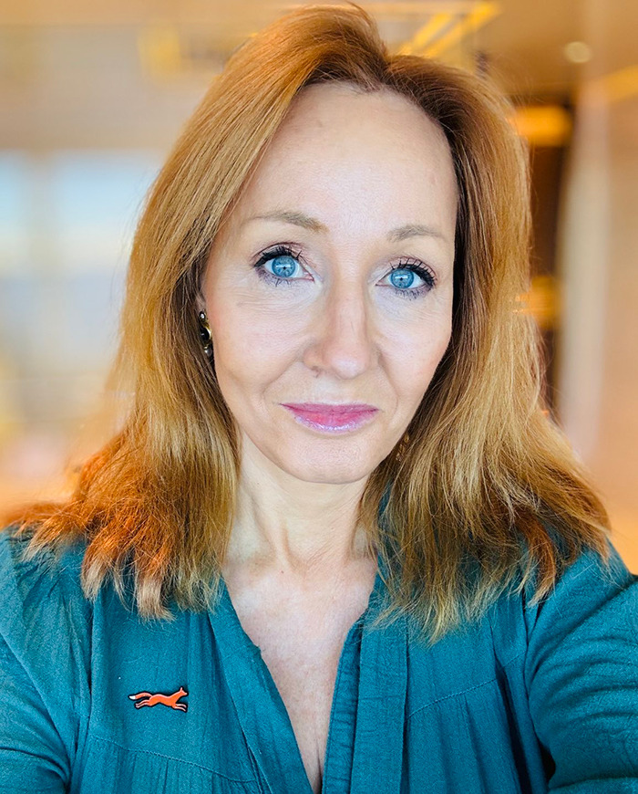 Woman with blue eyes and red hair in a teal shirt, related to objections to a New York Times article.