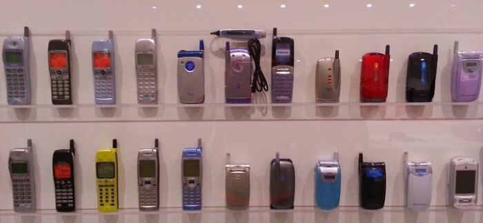 Old cellphones displayed on a wall reflecting an old-internet feel.
