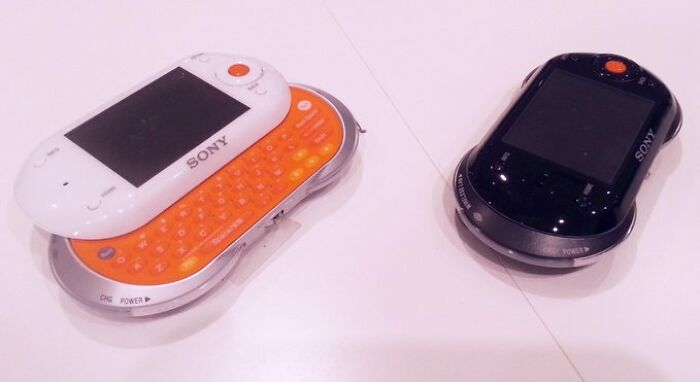 Two retro Sony devices with sliding keyboards, showcasing old-internet-feel aesthetics on a white surface.