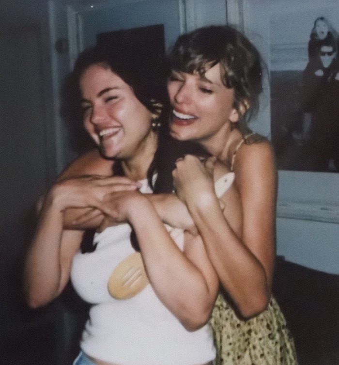 Selena Gomez and Taylor Swift smiling and hugging in casual setting.