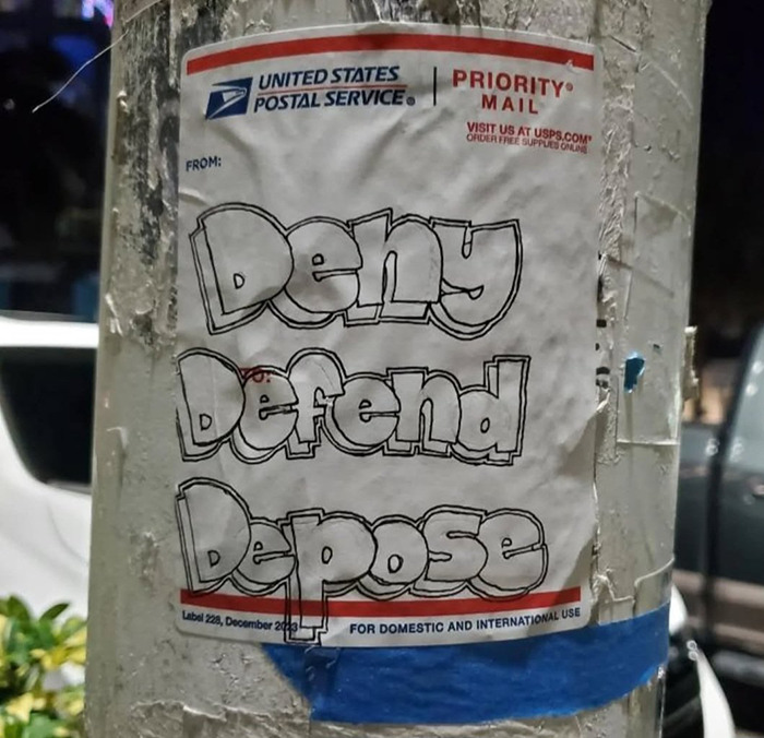 USPS sticker with "Deny Defend Depose" graffiti. USPS sticker with "Deny Defend Depose" graffiti.
