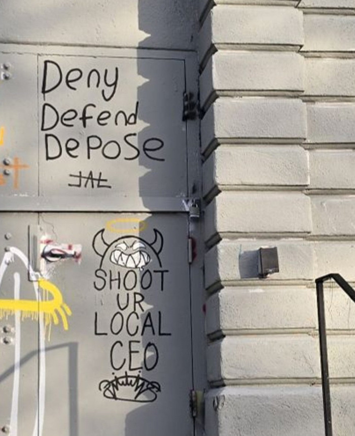 Graffiti on a wall with slogans including "Shoot Ur Local CEO" and "Deny Defend Depose. Graffiti on a wall with slogans including "Shoot Ur Local CEO" and "Deny Defend Depose.