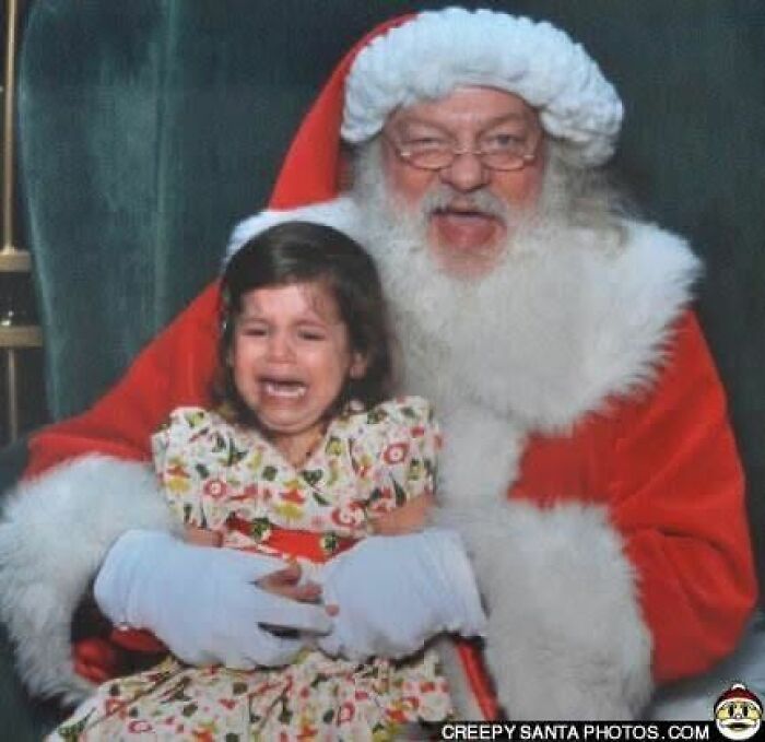 A crying child on the lap of a Santa in a red suit, embodying creepy Santas.