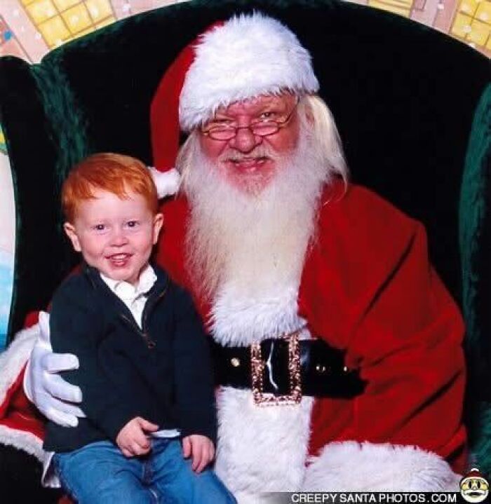 Child sitting with a smiling Santa in festive attire. Creepy-Santas theme.