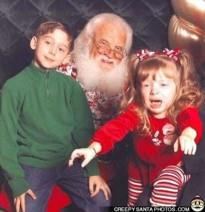 Young girl crying next to creepy Santa, with her brother smiling beside her.