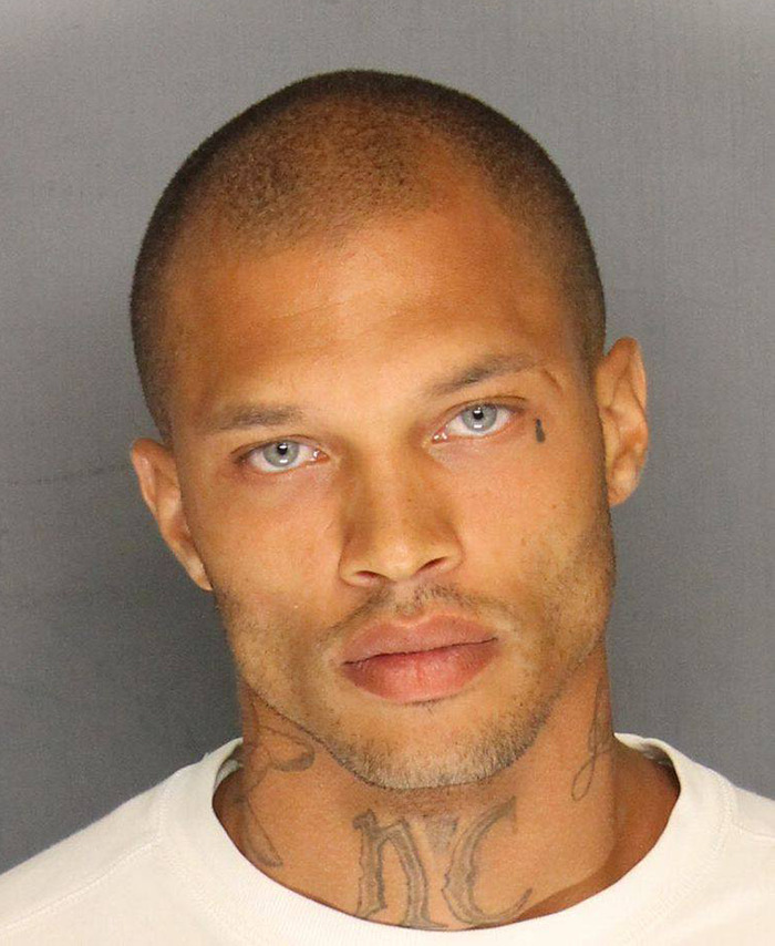 Viral mugshot of Jeremy Meeks with tattoos and blue eyes, wearing a white shirt.