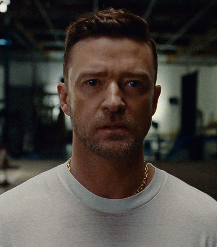Justin Timberlake in a white shirt and gold chain in a dimly lit room, highlighting a wardrobe malfunction. Justin Timberlake in a white shirt and gold chain in a dimly lit room, highlighting a wardrobe malfunction.