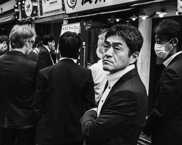 Businessmen in Tokyo's bustling streets, reflecting the fast-paced life, captured in black and white.